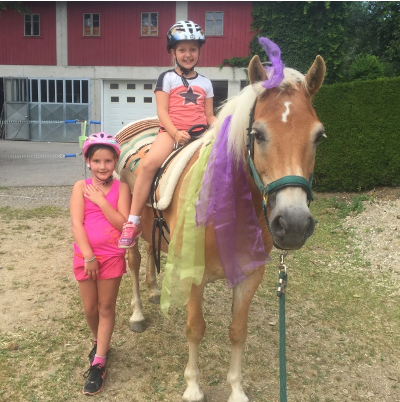 Kinder sitzen auf Pferd