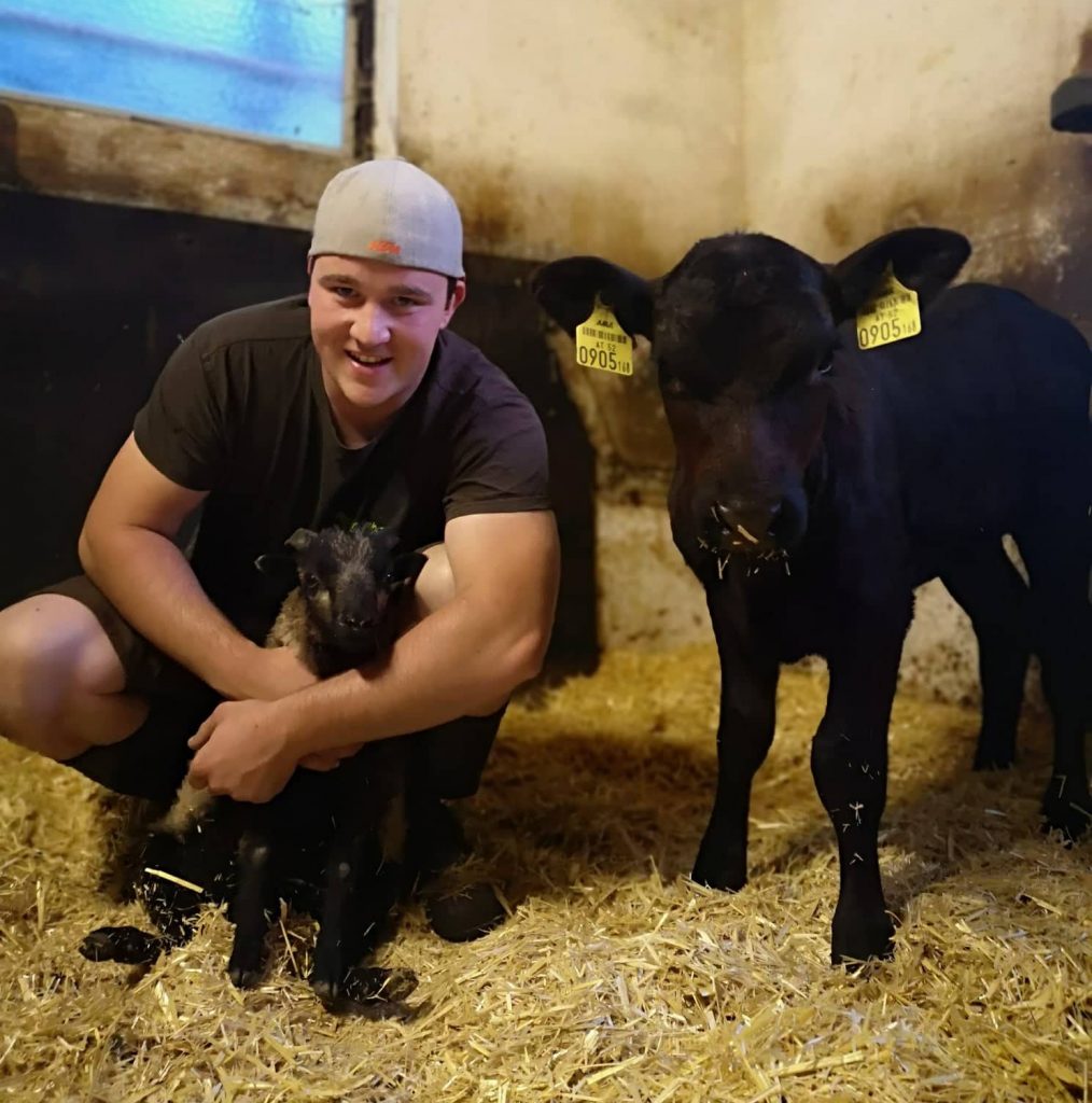 Florian Baumgartner im Stall mit Kälber